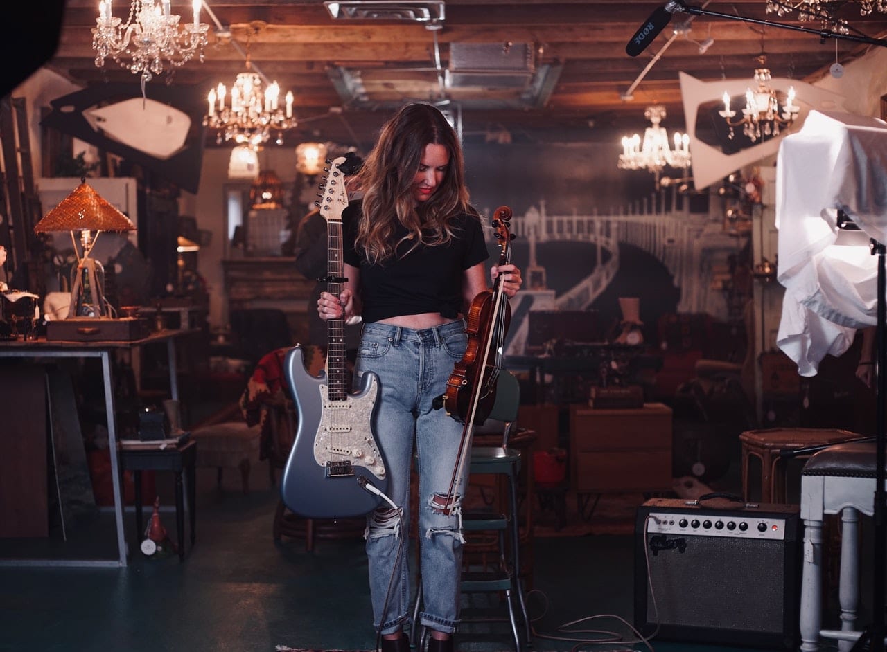 photo of woman standing while holding an electric guitar and 4372214